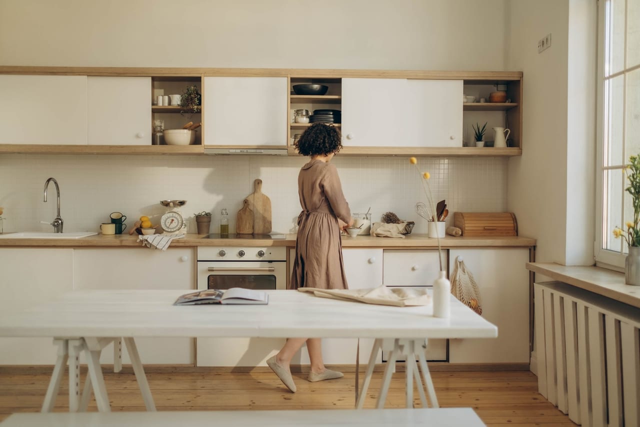 Woman in soft slip-on shoes standing at a kitchen counter on a wooden floor